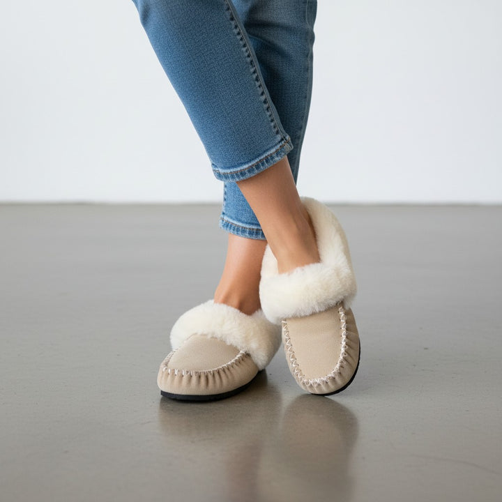 The Skin Thing HUGLIE sheepskin moccasins in tan suede with white fluffy lining and white stitching detail.